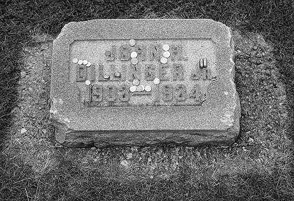 歹徒约翰·迪林杰的墓碑上有硬币和子弹`Gravestone of the Gangster John Dillinger with Coins and Bullets by Carol McKinney Highsmith